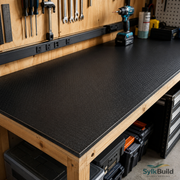 Workbench with black textured surface and tools in a workshop setting, featuring SylkBuild branding.